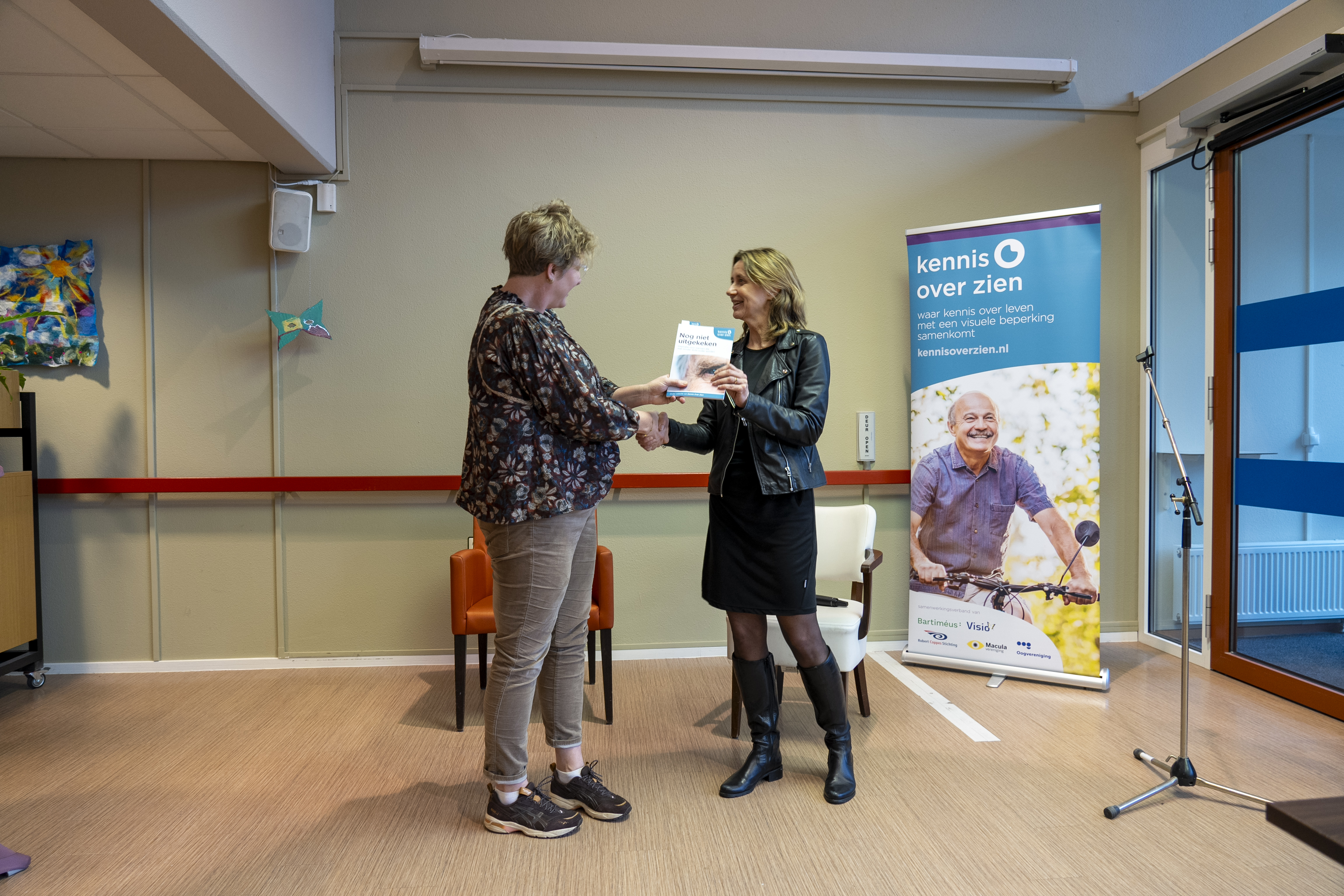 Annelies Versteegden (voorzitter Raad van Bestuur Koninklijke Visio) ontvangt het eerste exemplaar uit handen van Karin Topper (projectcoordinator)