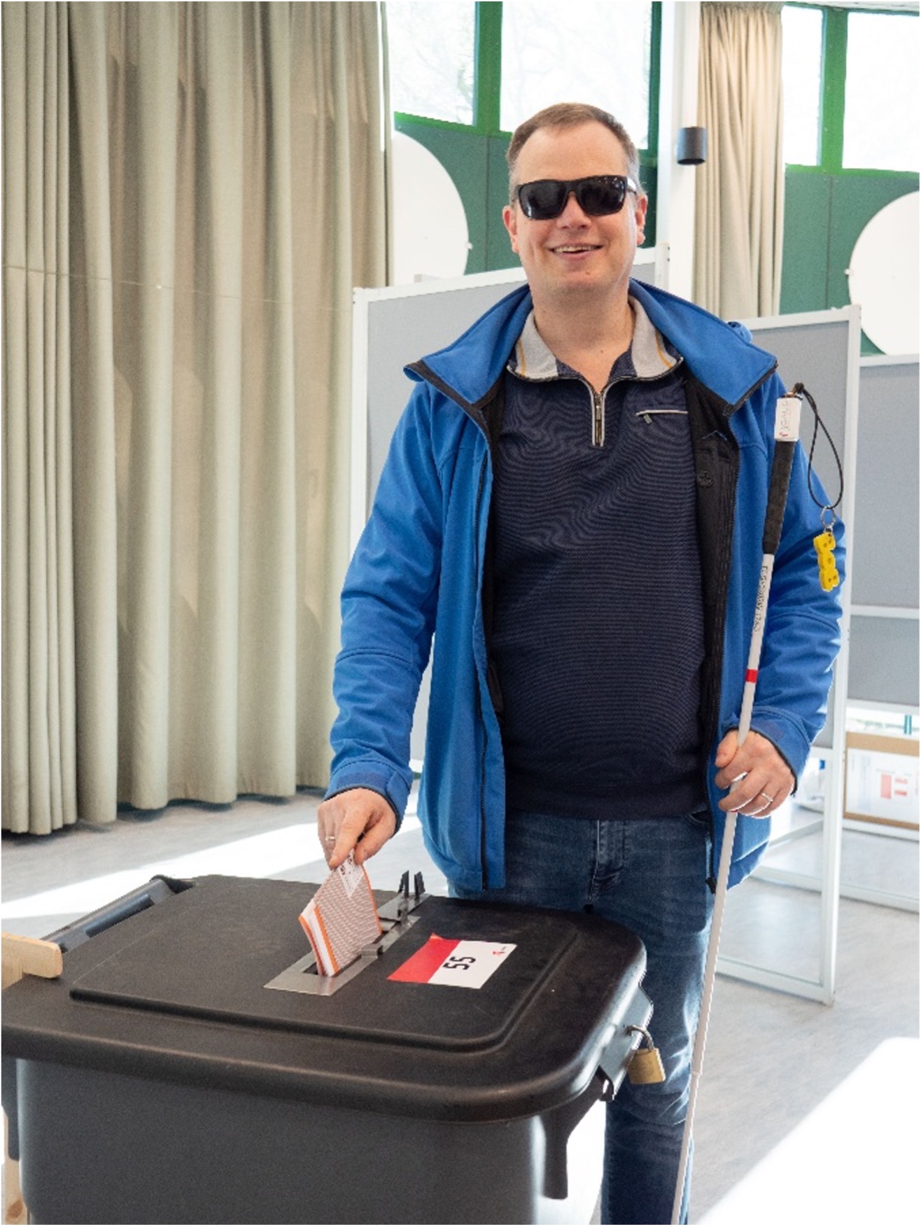 Foto van Peter Waalboer die stembiljet in de stemcontainer doet