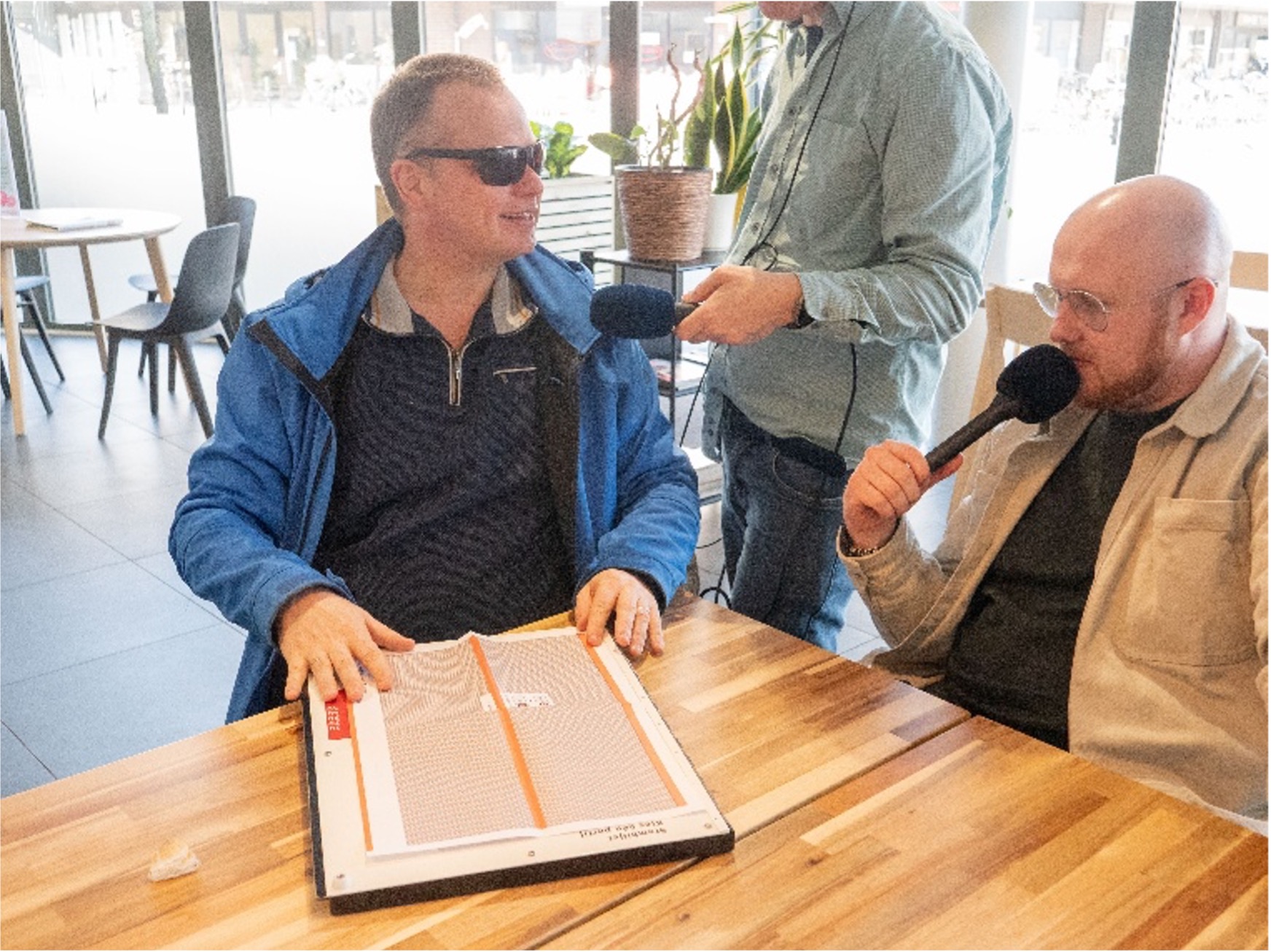 Foto van Peter Waalboer die stemmal probeert terwijl hij zijn bevindingen in de microfoon vertelt