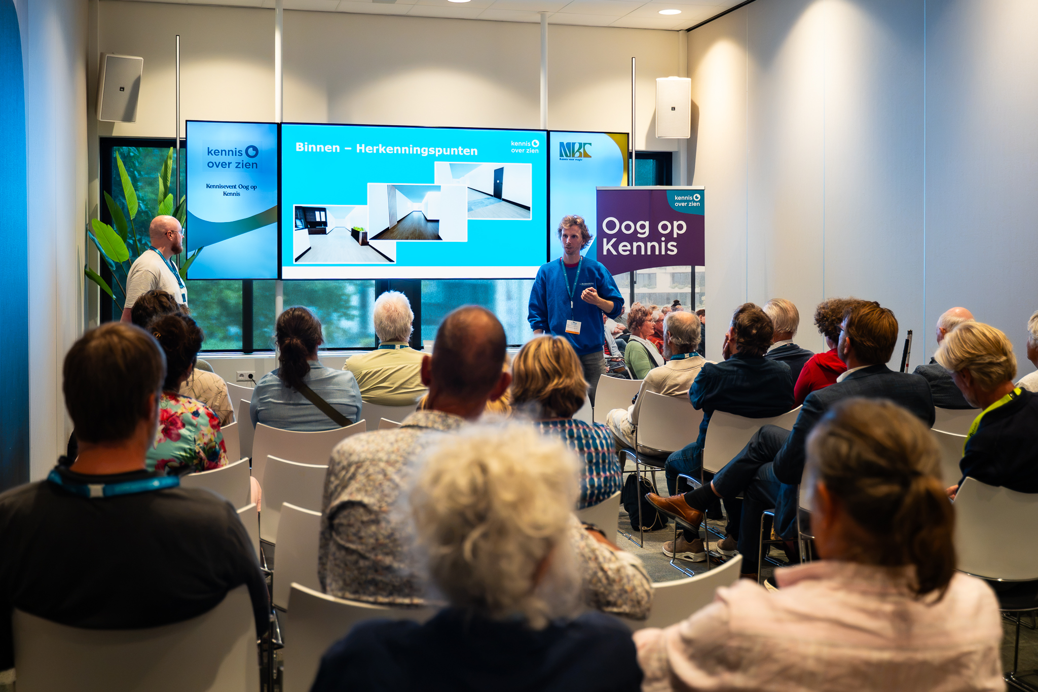 Deelnemers in workshopzaal, kijkend naar een digitaal scherm