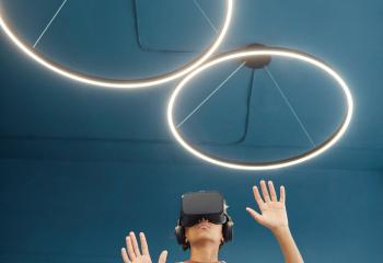 Persoon met VR-bril op beweegt met handen in de lucht.