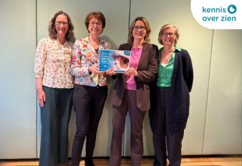 Vier vrouwen poseren met rapportage. Logo Kennis Over Zien.